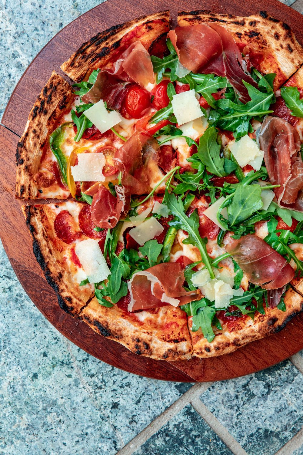Pizza au jambon cru, à la roquette et aux copeaux de parmesan